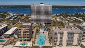 Un hôtel de grande hauteur doté d’une cour intérieure, de nombreux balcons et offrant une vue sur une vaste étendue d’eau.