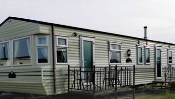 A mobile home with a porch and a chimney, labeled 'Plum Caravan'.