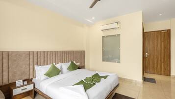 A hotel room with a bed, nightstand, and a ceiling fan.