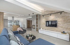 Una Smart TV, una chimenea, una mesa de tenis de mesa