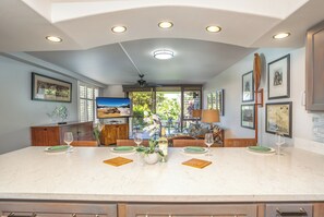 A spacious kitchen with a large island, modern appliances, and a view to the outdoors.