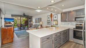 A modern kitchen with a large island, built-in appliances, and a dining area with outdoor seating.