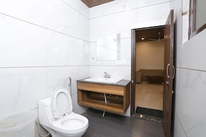 A modern bathroom with a white toilet, a wooden vanity with a sink, and a mirror above the sink.