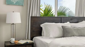 A neatly made bed with white and gray pillows, a bedside table with a lamp, a book, and a cup. - 9 Bedrooms-7 Bath-2 Kitchens-Parking-Sleeps 22! (San Diego)