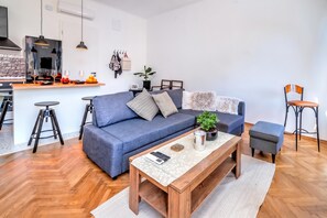 Una sala de estar moderna con un sofá, una mesa de centro y taburetes de bar.