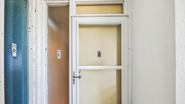 A door with a mesh screen, a metal handle, and a keyhole.