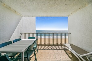 Un balcon avec vue sur la plage et l’océan.