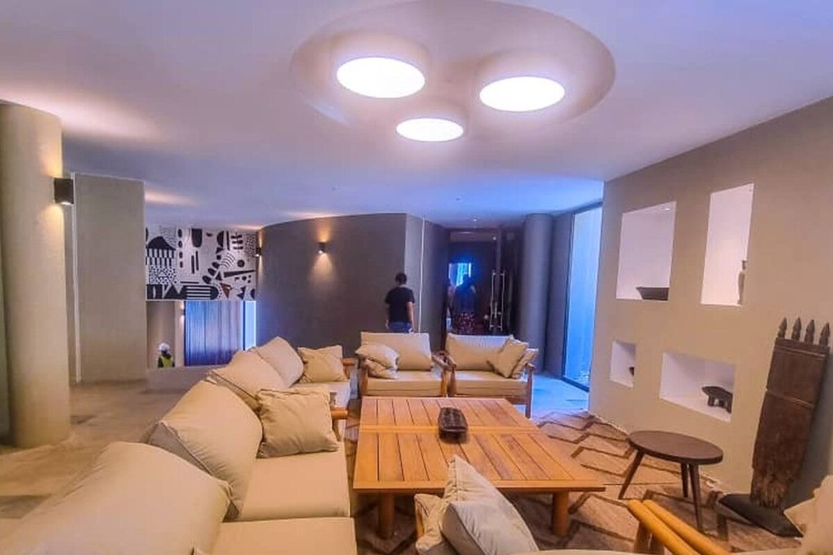 A modern living room with a sofa set, a wooden coffee table, and a small round table.