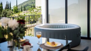 Un coin repas avec une table dressée pour deux personnes, un espace salon confortable et une vue sur un paysage montagneux.
