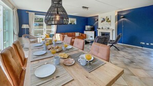 A dining area with a wooden table set for breakfast, surrounded by leather chairs.