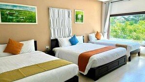 A hotel room with three beds, a large window with a view of greenery, and artwork on the walls. - Pearl Beach Homestay (Da Nang)