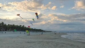 A beach with footprints in the sand and a few people in the distance. - Pearl Beach Homestay (Da Nang)