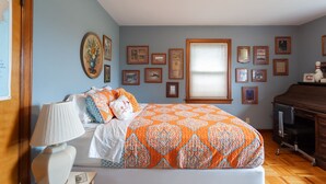 A bedroom with a bed, a lamp, a dresser, and a window. - Acreage Near Downtown (Indianapolis)