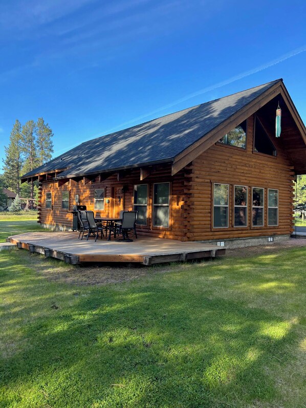 A log cabin with a deck, outdoor seating, and large windows. - Cozy 3 bedroom, 3 bathroom, Log Home, PET FRIENDLY, Tollgate (Sisters)