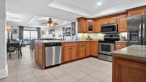 A modern kitchen with wooden cabinets, stainless steel appliances, and a central island.