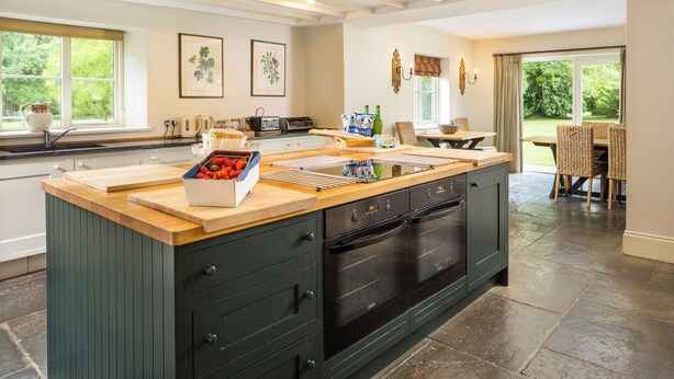 A spacious kitchen with a large island, built-in appliances, and a view of the garden through the windows. - Monnington House & Cottages Sleeps 24 12 beds & 12 baths nr Hereford &Hay on Wye (Hereford)