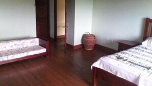 A bedroom with a wooden floor, a sofa, a bed, and a large woven basket. - Romantic 1 Bedroom Splendora (Gros Islet)