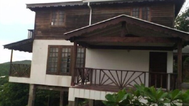 A two-story wooden house with a balcony and a small porch. - Romantic 1 Bedroom Splendora (Gros Islet)