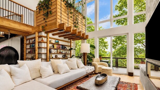 Un salon spacieux avec un grand canapé, une table basse et une bibliothèque.