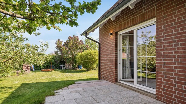 Ein Ziegelhaus mit Terrasse und einer großen Glaswand.