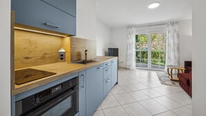 Eine moderne Küche mit einer Holz Arbeitsplatte, einem Einbauofen und einem Spülbecken.