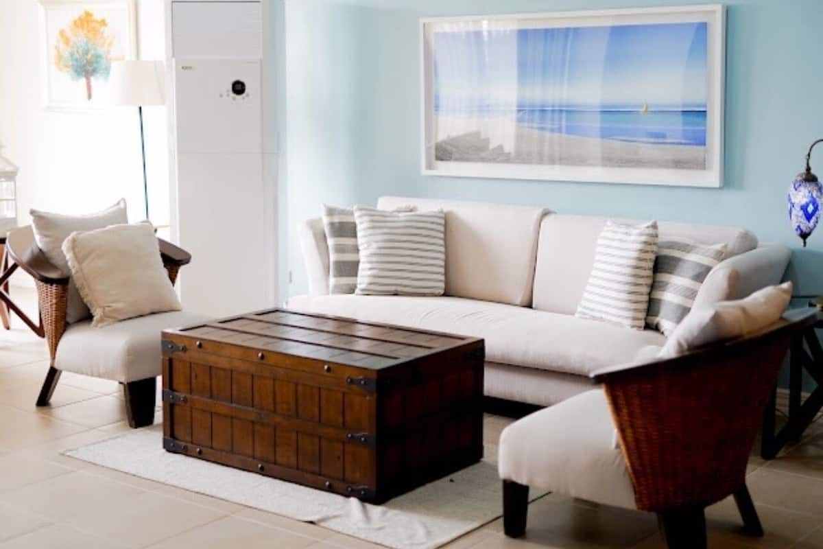 A living room with a sofa, armchairs, a wooden coffee table, and a framed picture on the wall.