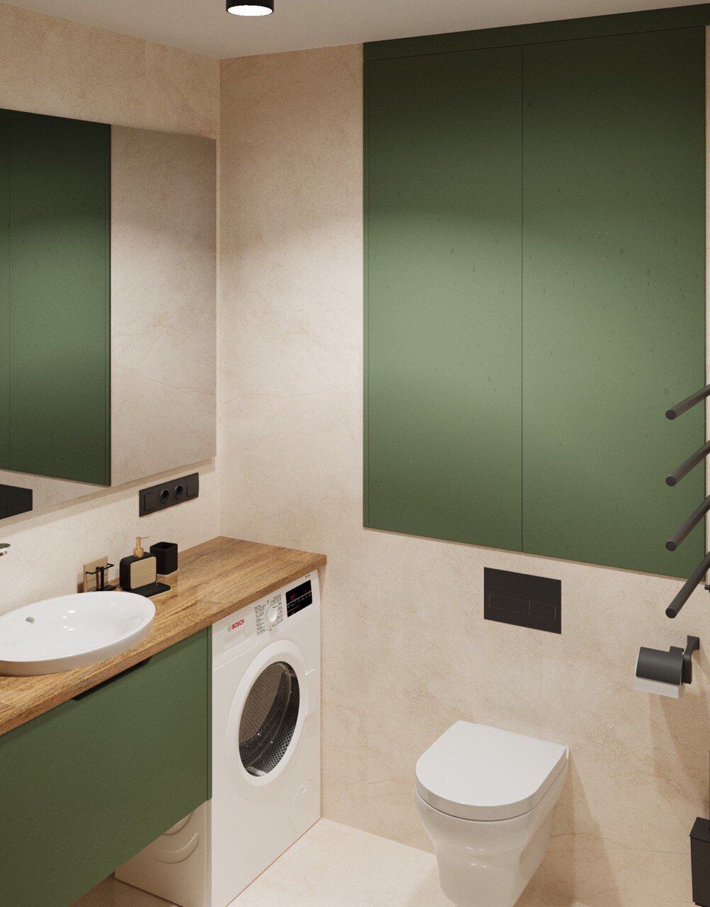 A modern bathroom with a wooden vanity, a washing machine, a toilet, and green cabinets.