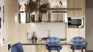 A modern kitchen with a central island, two bar stools, and a built-in TV. - Manhattan High Line Apart (Kyiv)