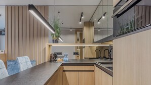 A modern kitchen with wooden cabinets, a granite countertop, and a built-in stove. - Manhattan High Line Apart (Kyiv)