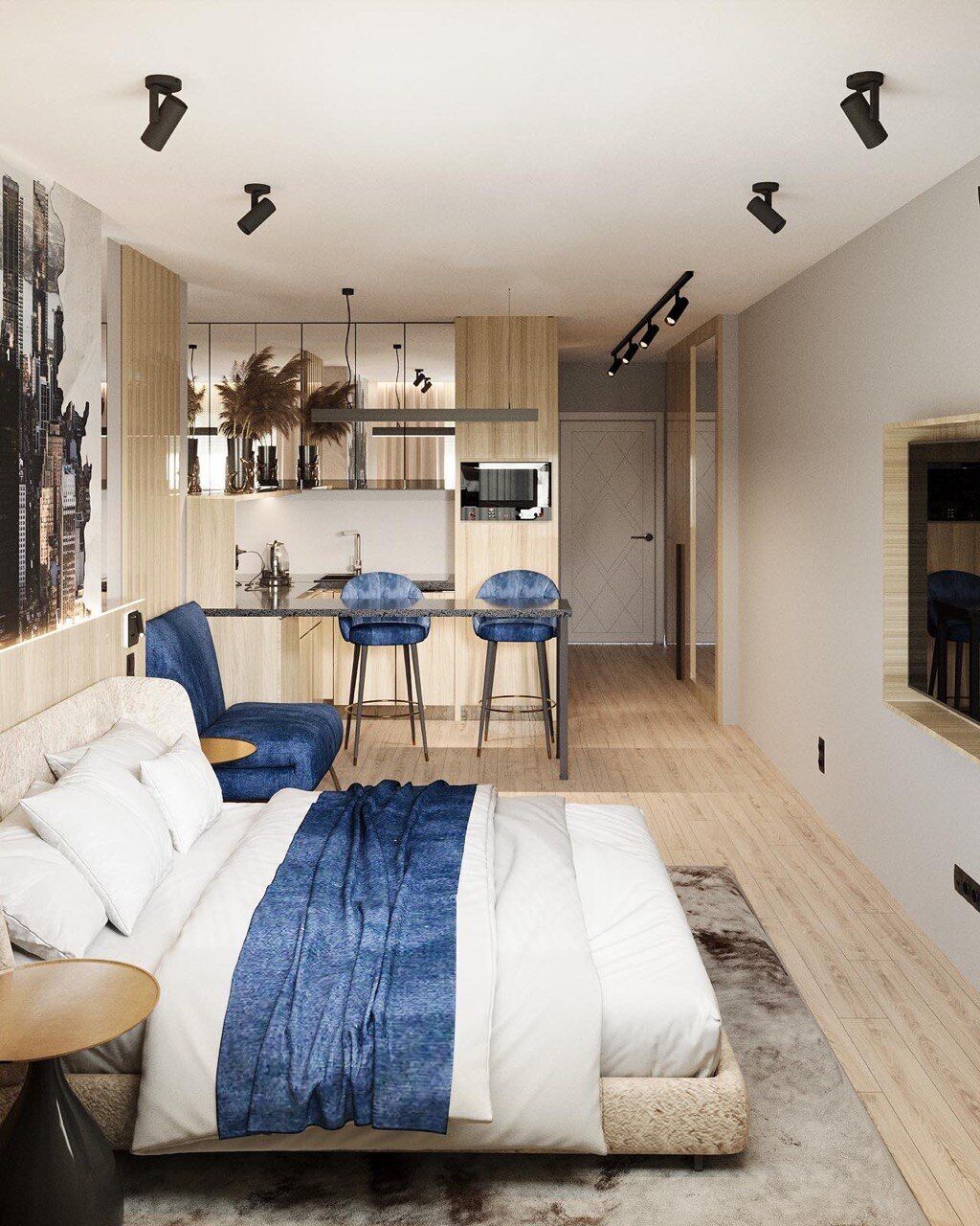A modern bedroom with a large bed, a desk, and a kitchenette.
