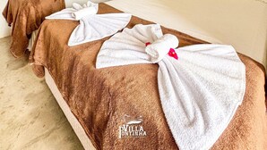 A hotel room with two beds, a large mirror, and an air conditioning unit on the wall. - Villa Pontinha (Amontada)