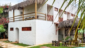A white building with a pool, thatched roofs, and wooden furniture. - Villa Pontinha (Amontada)