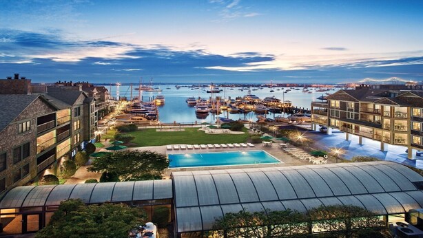 A marina with boats, a swimming pool, and buildings with balconies. - Harborfront Charm at Wyndham Onshore Resort (Newport)