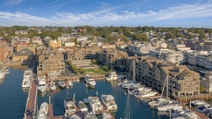 A marina with multiple boats docked, surrounded by residential buildings and greenery. - Harborfront Charm at Wyndham Onshore Resort (Newport)