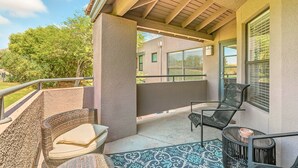 A covered balcony with wicker furniture and a patterned rug. - Exceptional upgrades makes for a perfect short or long term stay (TUCSON)