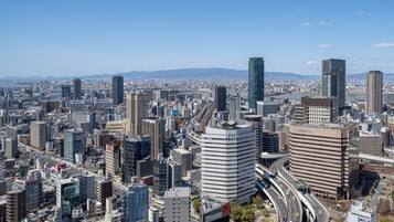 A cityscape with high-rise buildings, a highway, and a clear sky.