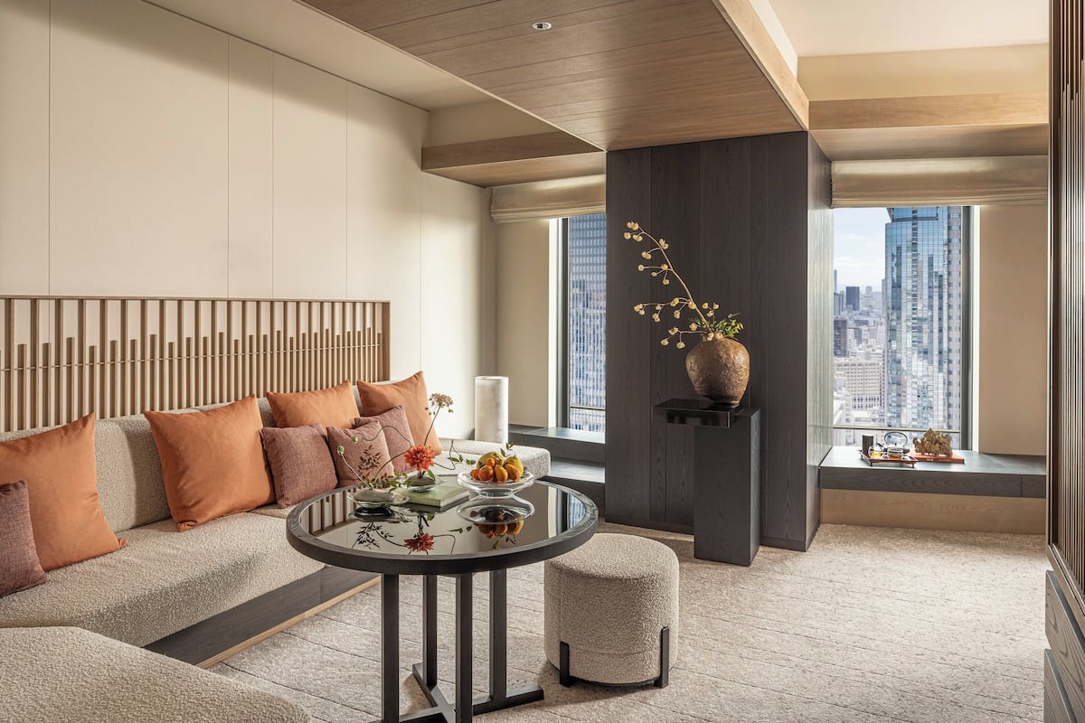 Een moderne woonkamer met een bank, een ronde tafel en een vaas met bloemen.