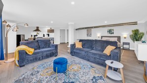 Un salon moderne avec deux canapés, un tapis rond et une petite table.
