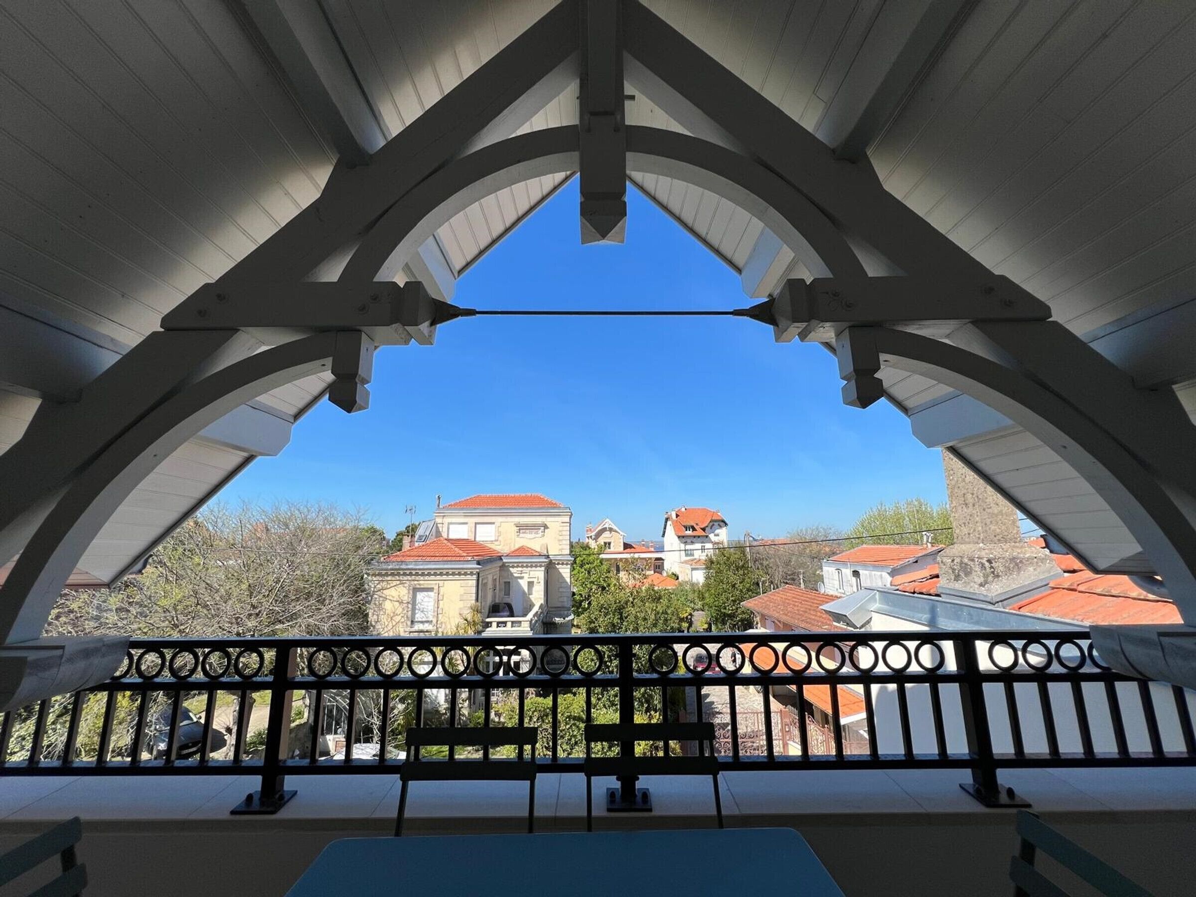 A balcony with a view of buildings and trees.