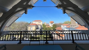 A balcony with a view of buildings and trees.