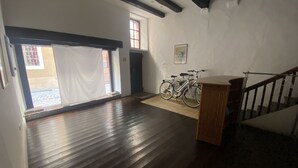 Ein geräumiges Zimmer mit Holzboden, einer Treppe und einem Fahrrad, das an der Wand lehnt.