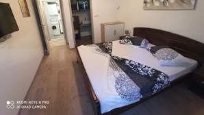 Une chambre à coucher avec un lit, une télévision, un tableau et une armoire.