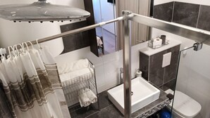 Une salle de bain moderne équipée d’une douche, de toilettes et d’un lavabo.