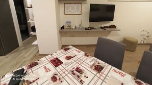 Un salon moderne avec un téléviseur à écran plat, une horloge murale et un tableau d’affichage.