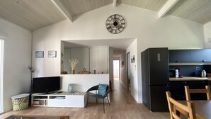 A spacious living area with a television, seating, and a kitchen area with appliances.