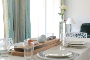 Une table à manger dressée avec des assiettes, des verres et un vase rempli de fleurs.