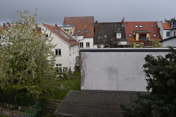 A residential area with various buildings, including a house with a red roof and a white building with a grey roof. - Alstadt kiek mal wedder in (Wismar)