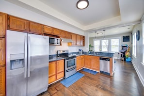 A modern kitchen with wooden cabinets, stainless steel appliances, and a large island.