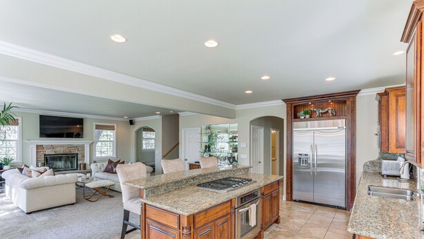 A spacious kitchen with granite countertops, wooden cabinets, a stainless steel refrigerator, and a built-in oven. - Lake Arrowhead Home: Mountain View, Walk to Water! (Lake Arrowhead)