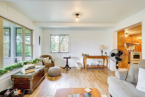 A cozy living room with a fireplace, a dining area, and a kitchen visible through an open door. - Detroit Lake Area Cabin 1/2 Mi to Santiam River (Gates)